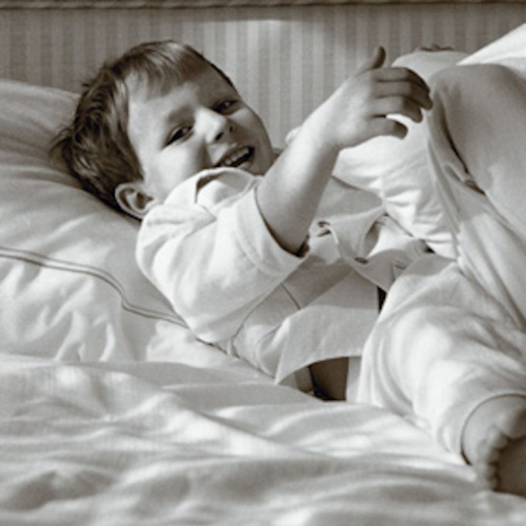Smiling child lying in bed at a family-friendly hotel in Washington, DC.