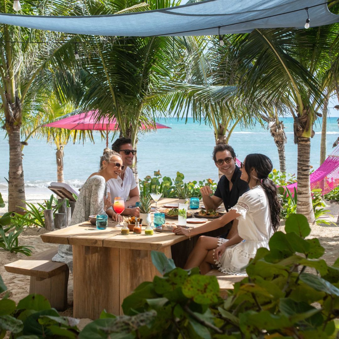 Group of friends having beachfront lunch at Aqui Me Quedo