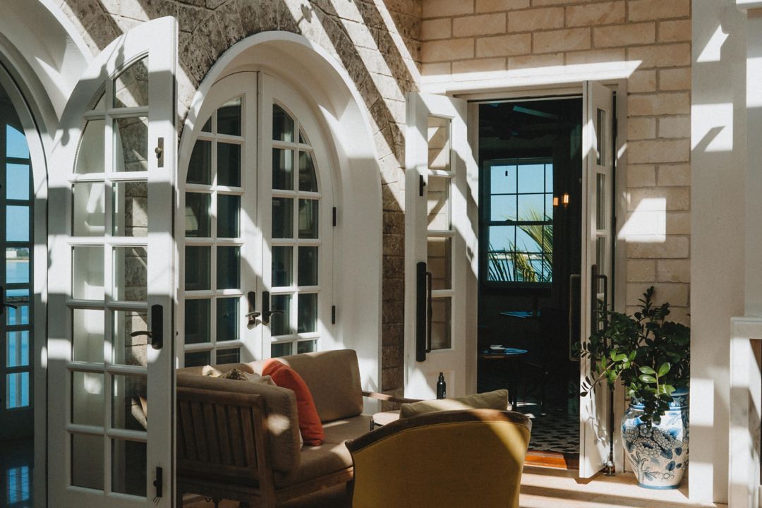 The interior of Conservatory Bar features a cozy couch and a veranda that welcomes streams of sunlight.