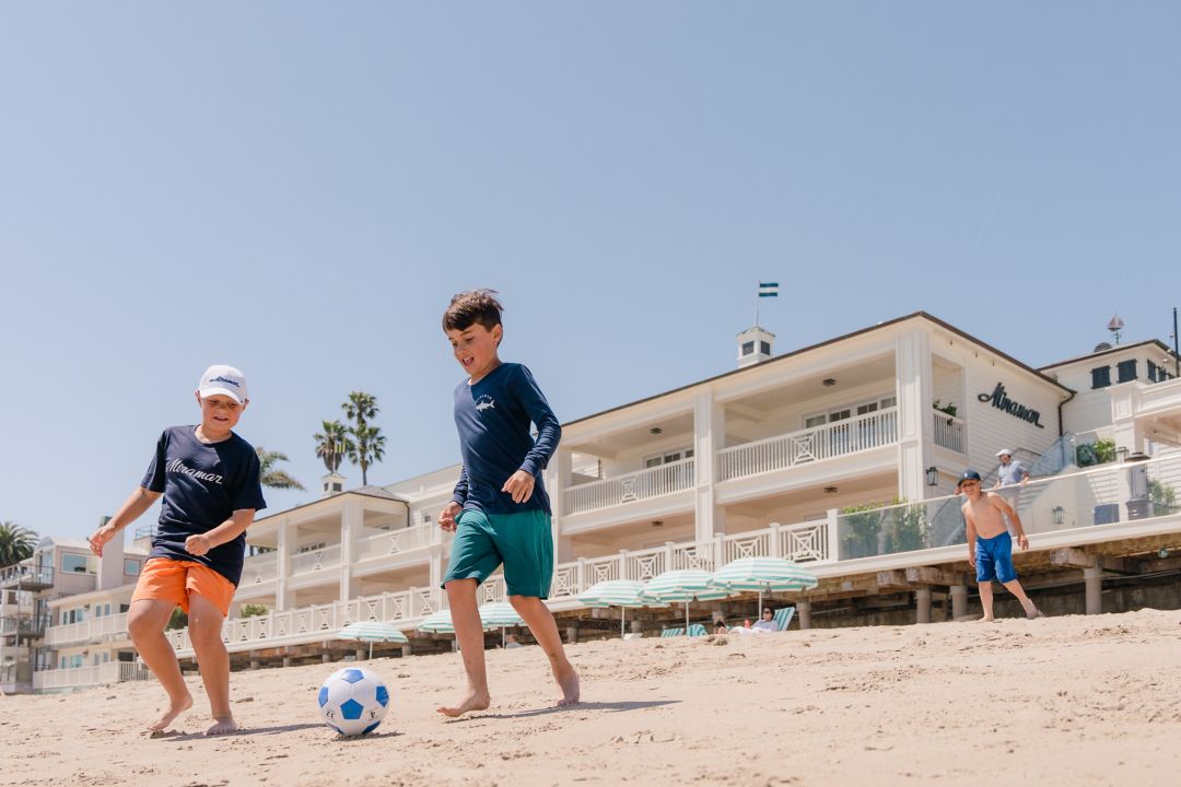 Kids playing soccer on the beach