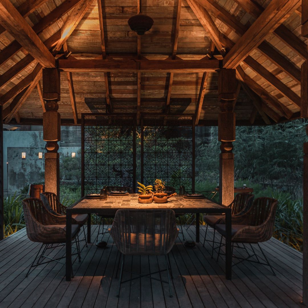 A dining area featuring a table with chairs on a wooden deck.
