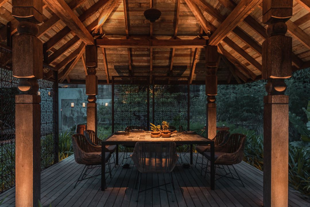A dining area featuring a table with chairs on a wooden deck.