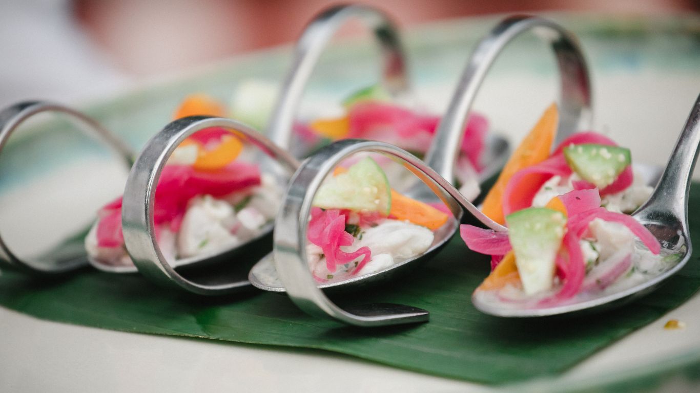seafood ceviche served on small silver spoons on serving platter