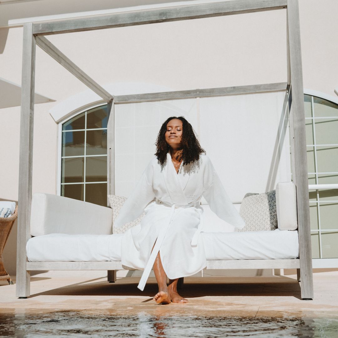 Avarie Graham resting by Sense Spa reflection pool on day bed.