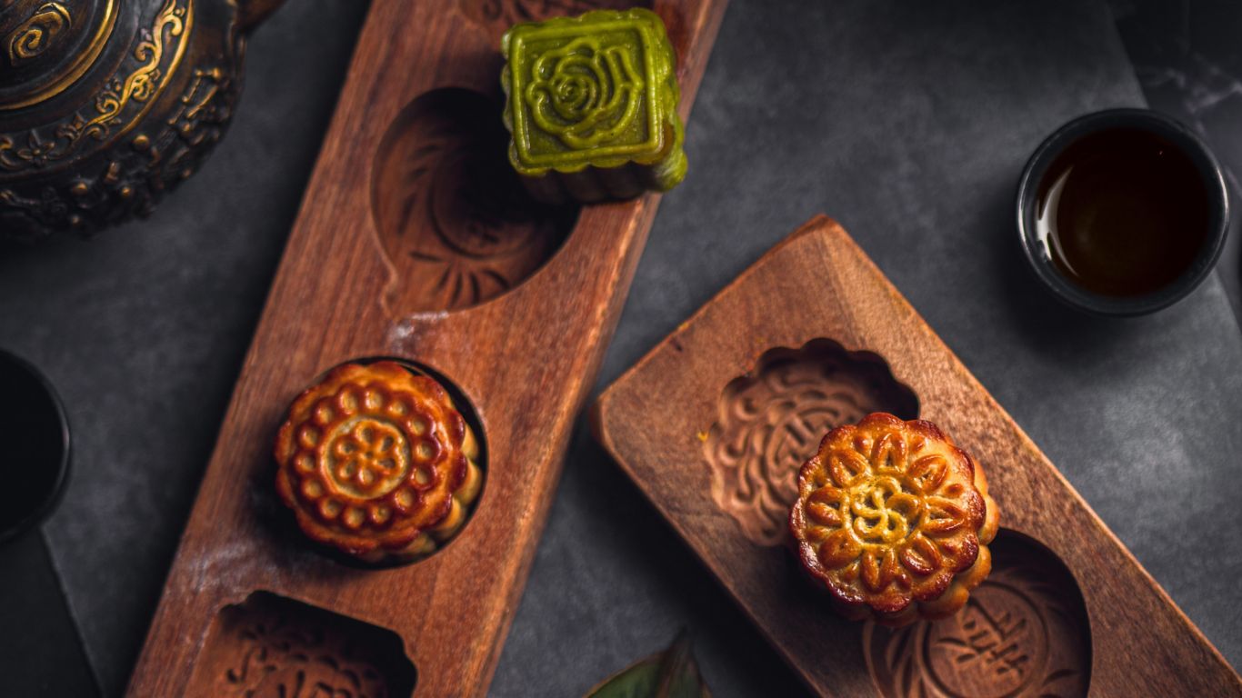 An exquisitely crafted mooncake adorned with intricate designs and placed on a beautifully set table, ready to celebrate the Mid-Autumn Festival