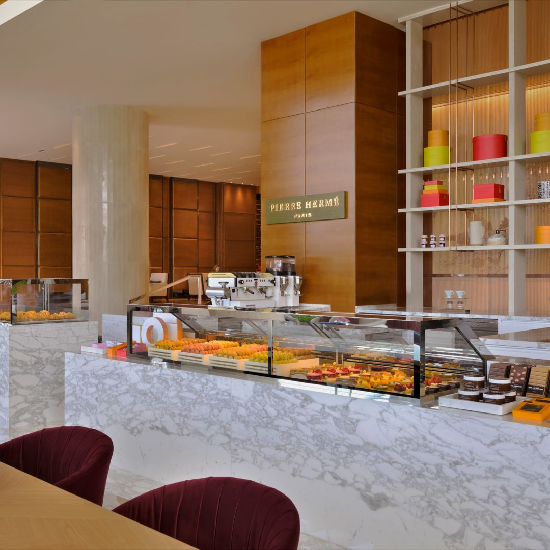 Elegant pastry shop interior with marble counter and colorful macarons.