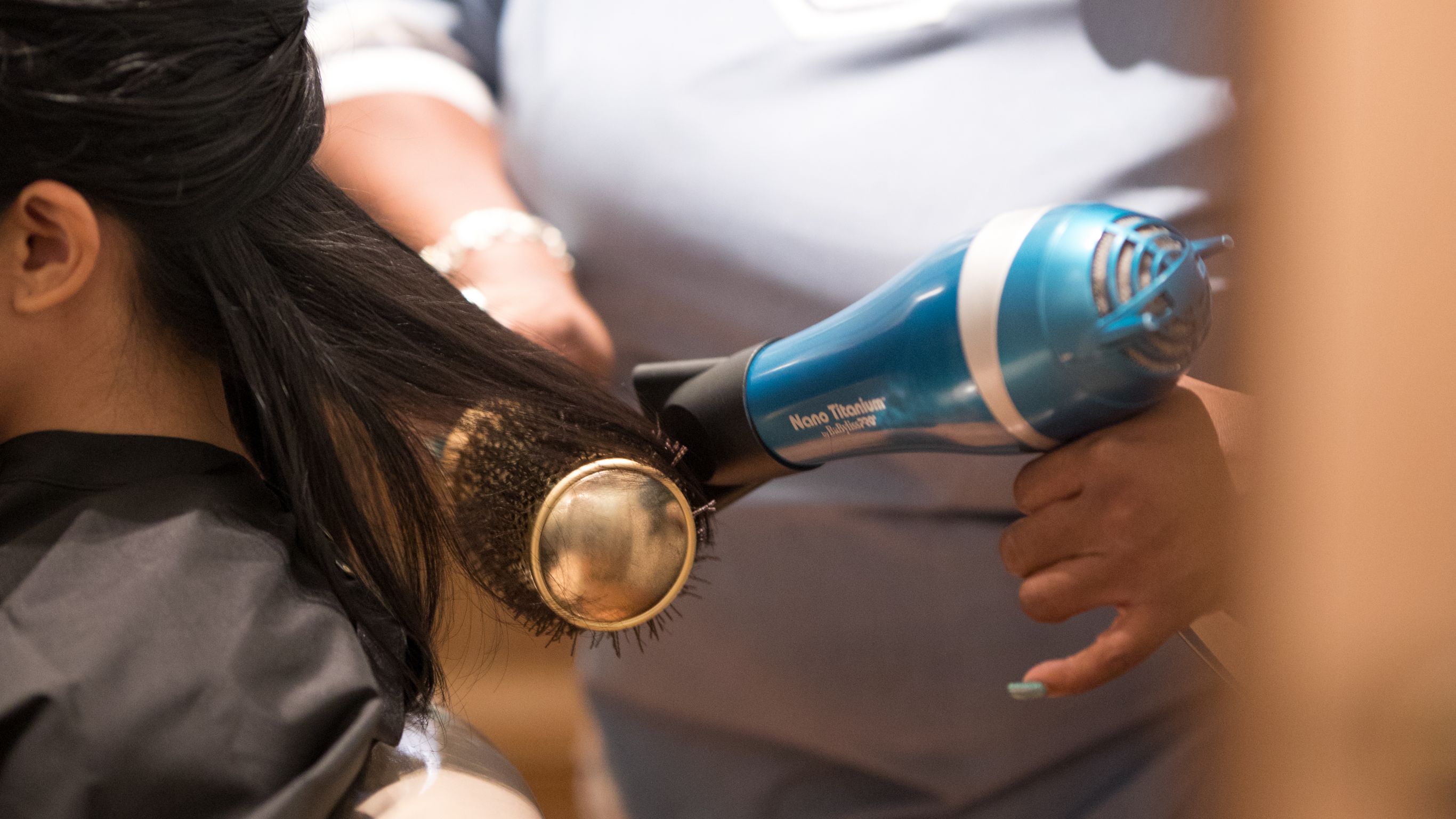 Woman getting hair blow-dryed