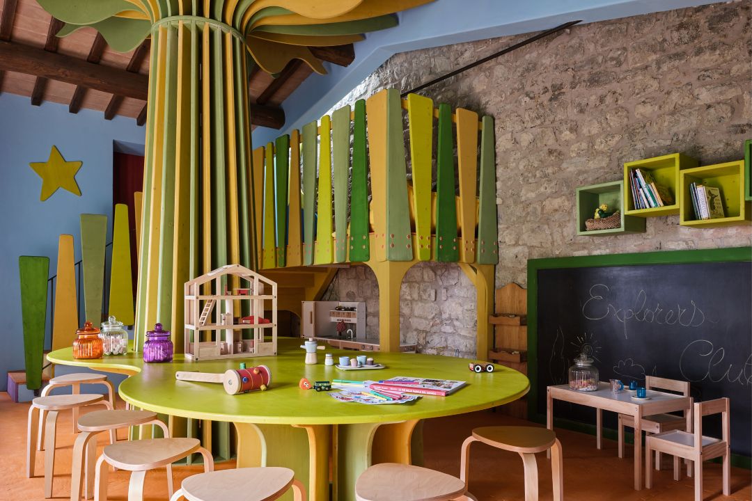 A kids space with round tables, chairs, and  toys.