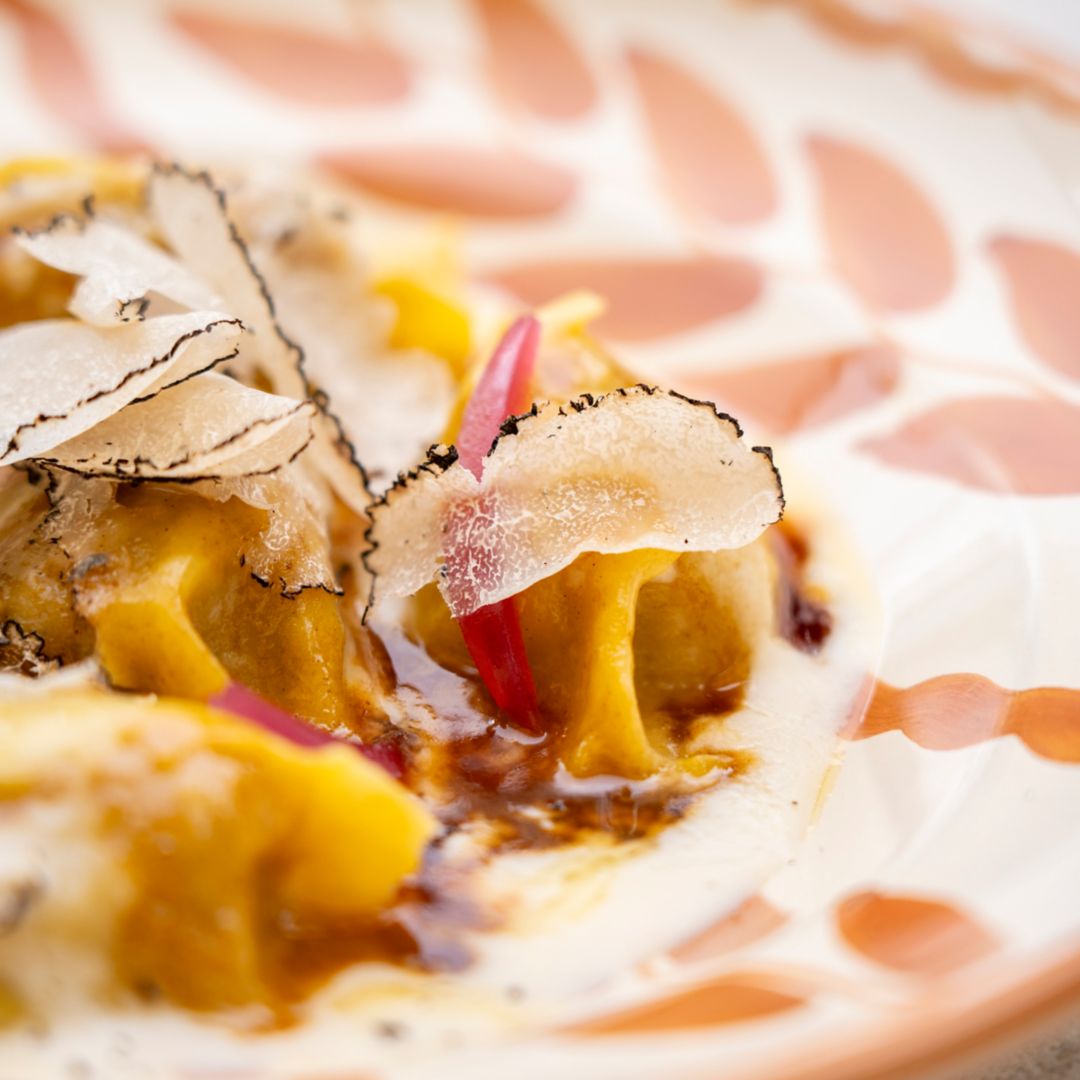Specialty tortelly dish with truffle from Osteria La Canonica on a colorful plate.