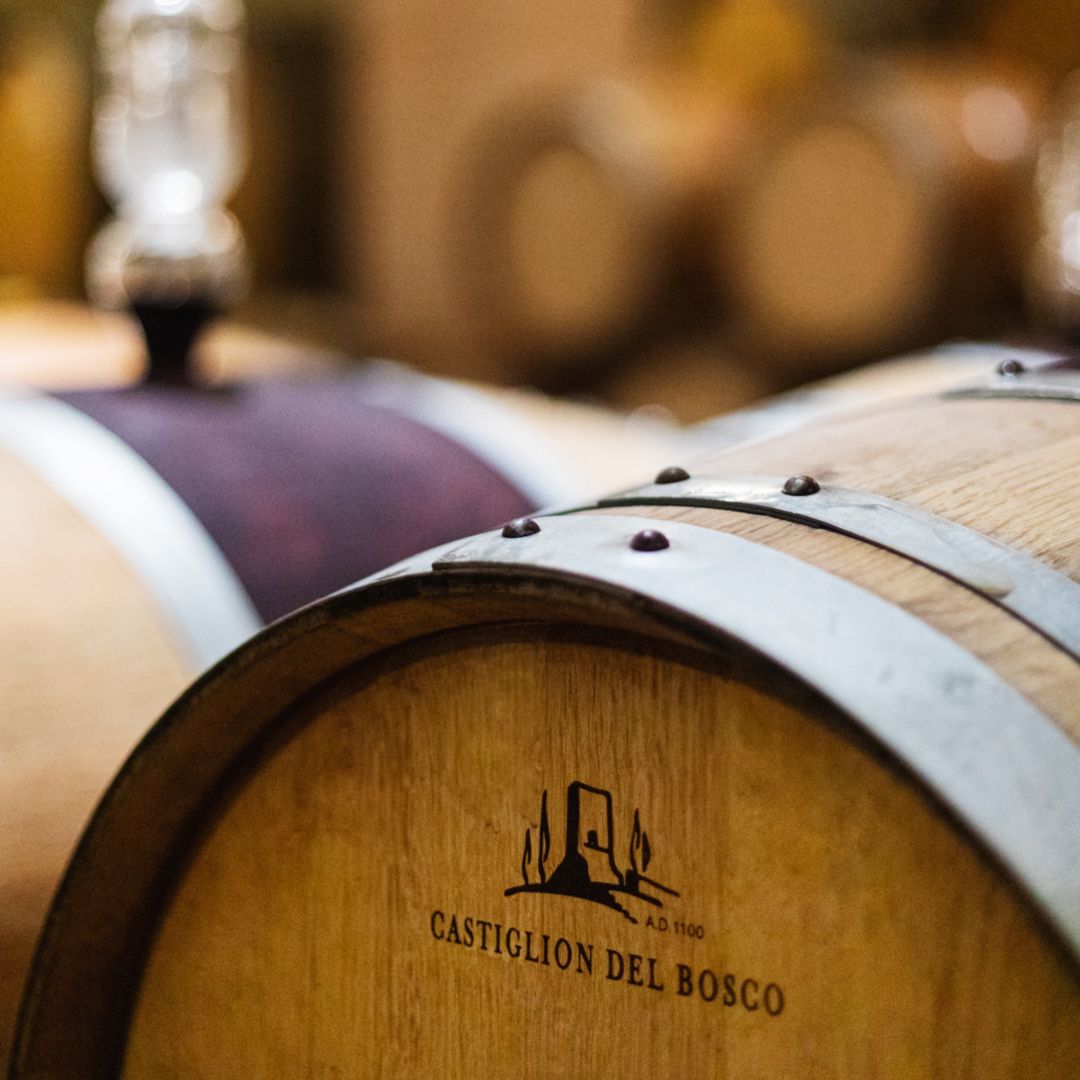 Wooden wine barrel with branding "Castiglion  Del Bosco" in a wine cellar.