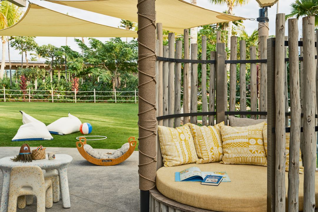 Family-friendly outdoor seating area with a circular bench featuring yellow cushions and pillows.