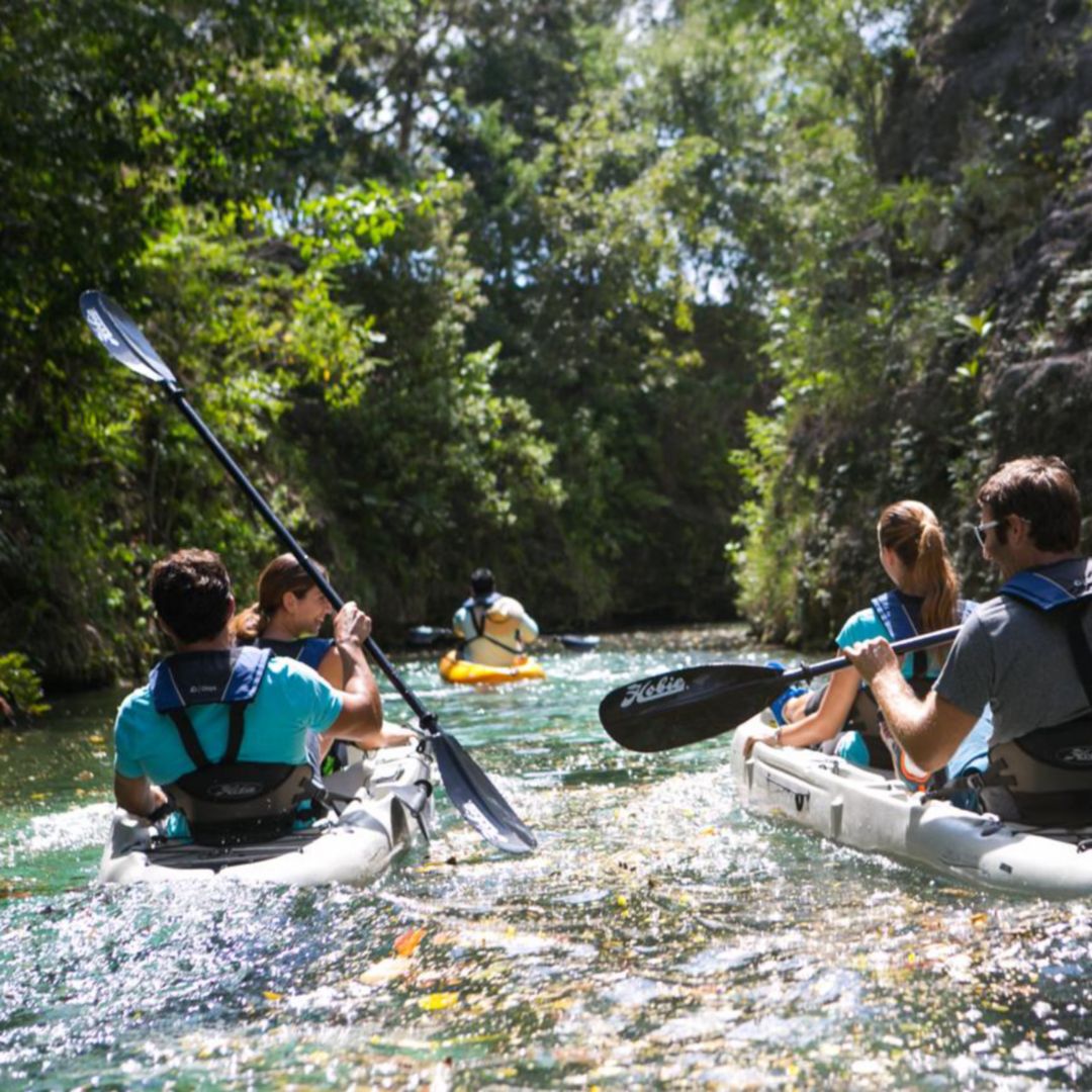 Cuatro personas, dos hombres y dos mujeres, kayak en lagunas con guía adelante