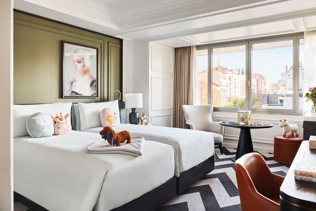 interior of the One Bedroom Suite showing a king bed with white sheets and grey painted walls at a hotel in Madrid