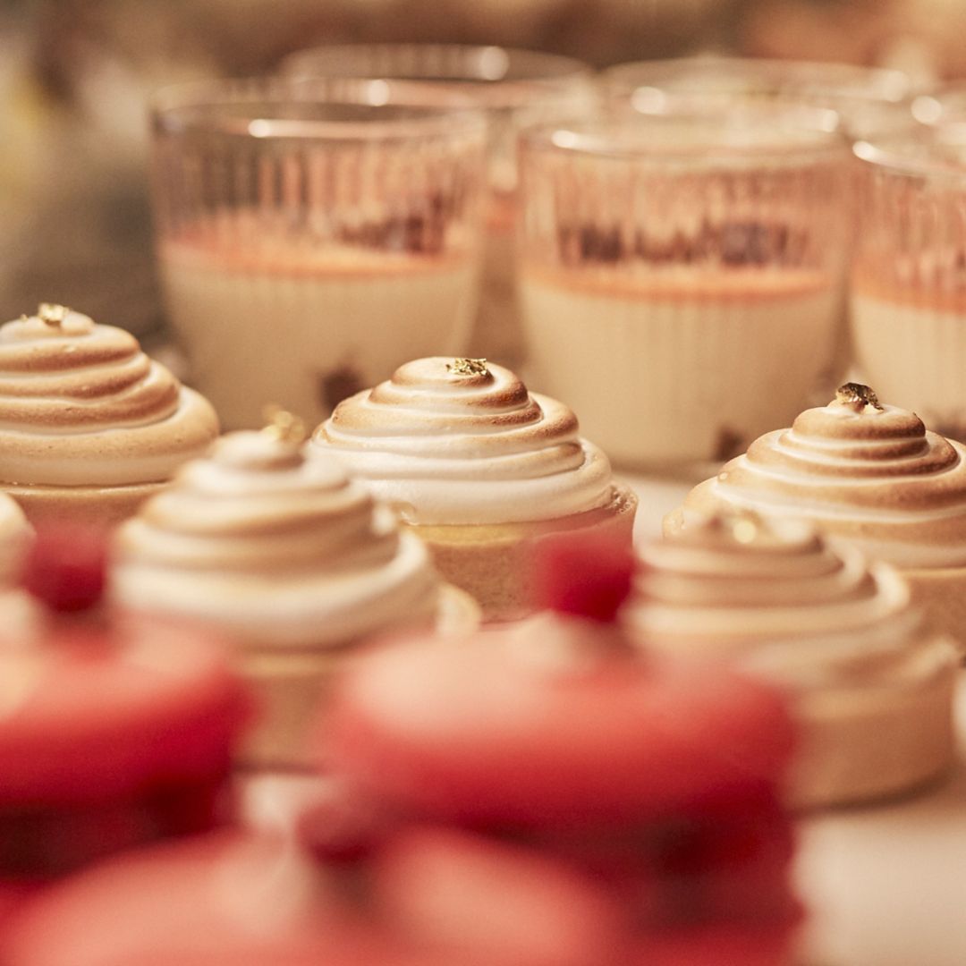 Postres y pasteles cubiertos con crema enrollada en flor y nata para el té de la tarde.