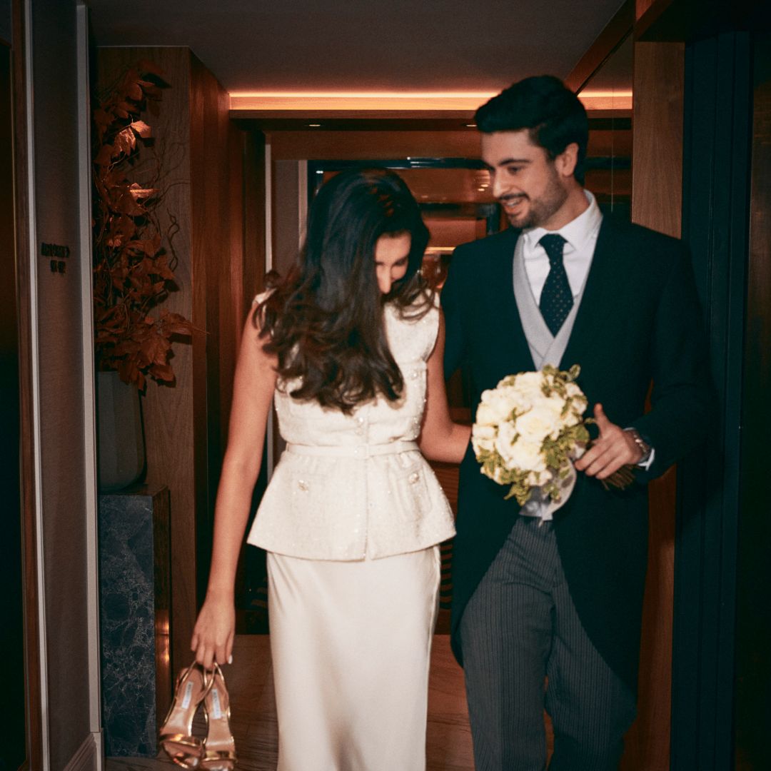 A bride and groom walking together at a hotel wedding venue.