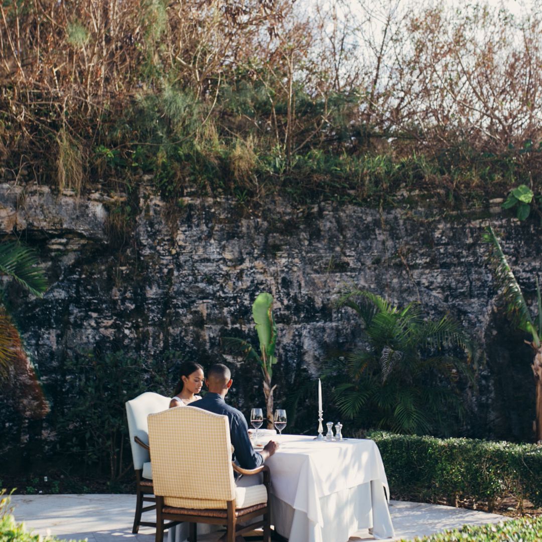 Couple dining in garden surrounded by limestone walls