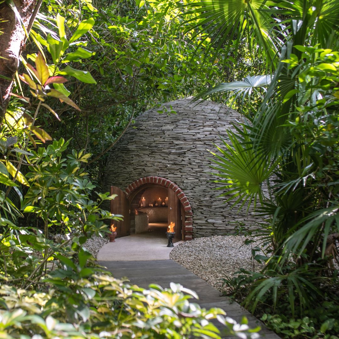 women in white dress kneeling with ceremonial drums and incense smoke for Rosewood Mayakoba's Marry Oneself Ceremony at Sense Spa