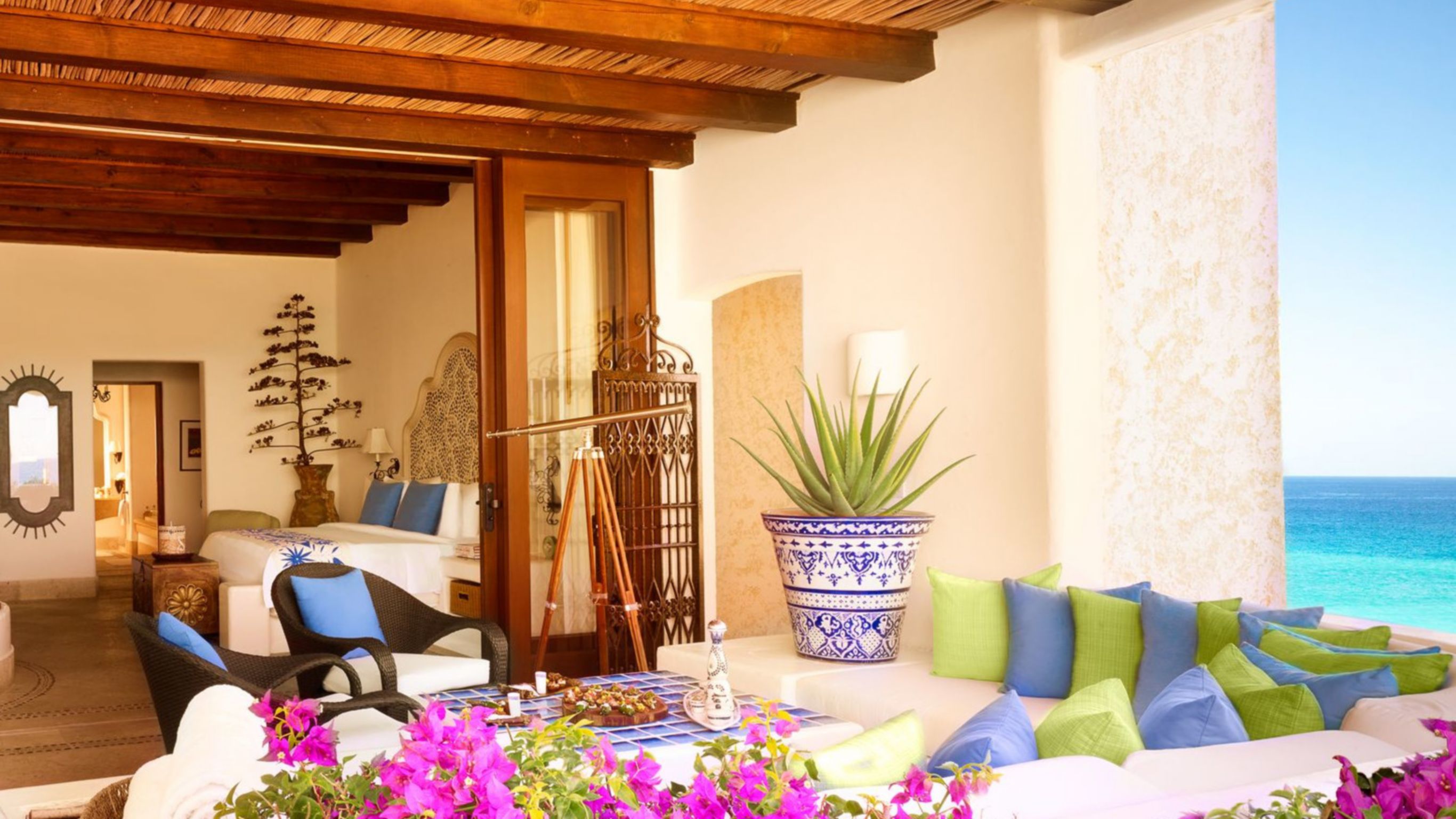 A luxury villa with a living area, bedroom and a private pool overlooking the ocean.