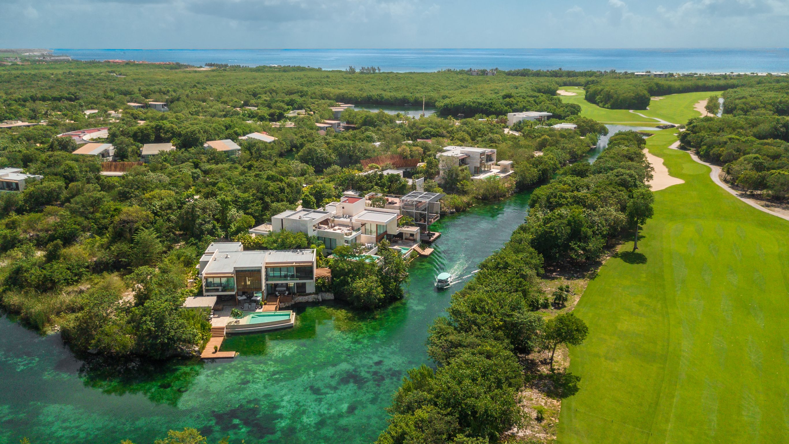 Aerial shot of Rosewood Mayakoba depicting winding lagoons, mangroves, villas and Caribbean Sea