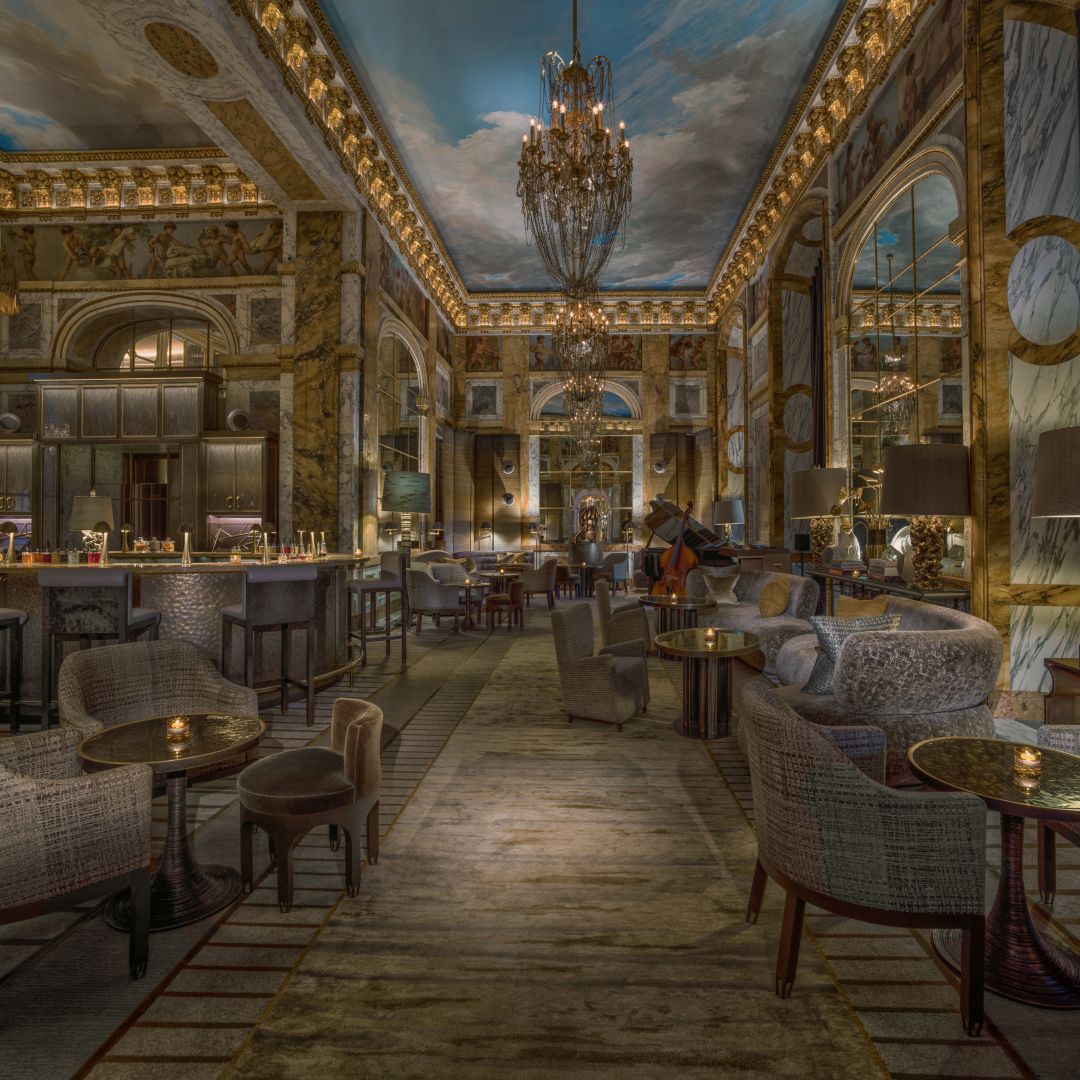 A luxury hotel bar in Paris with ornate gold detailing on the walls and ceiling.