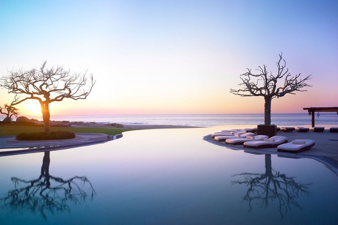 An infinity pool at a luxury resort in Los Cabos overlooking the ocean.