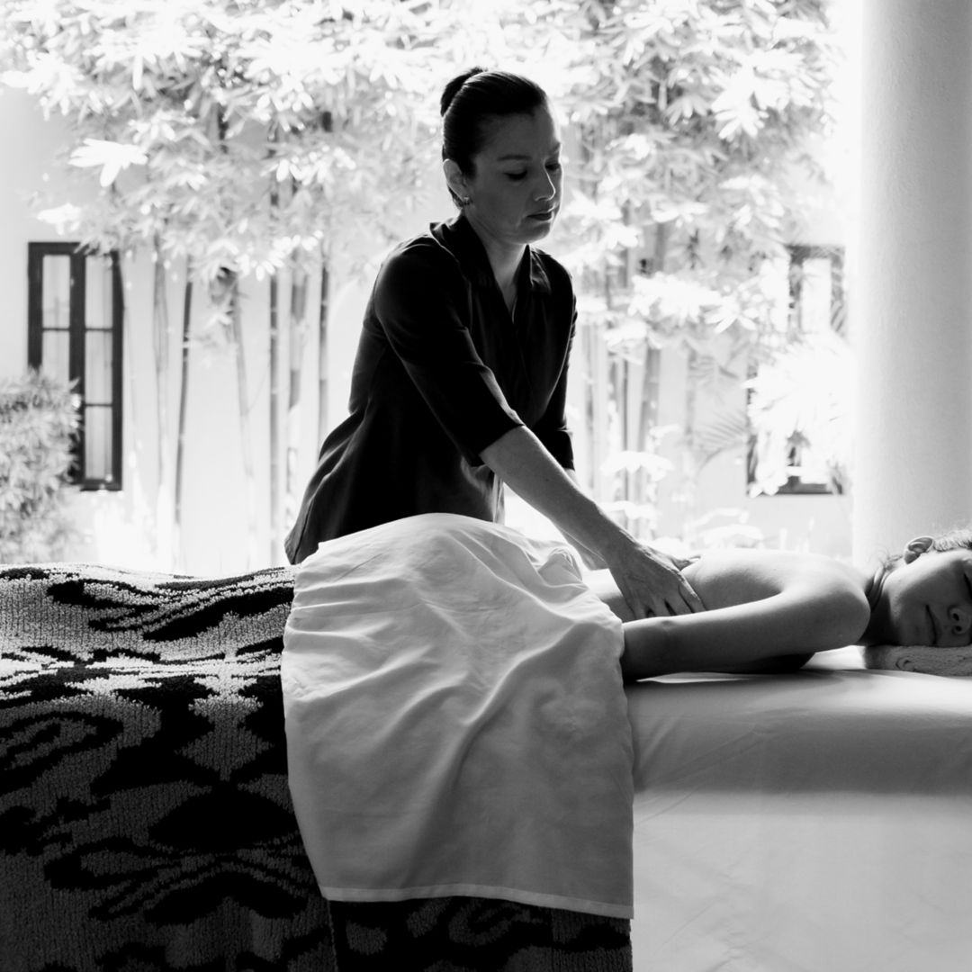 A therapist performing a massage on a client lying on a table at a spa in San Miguel de Allende.