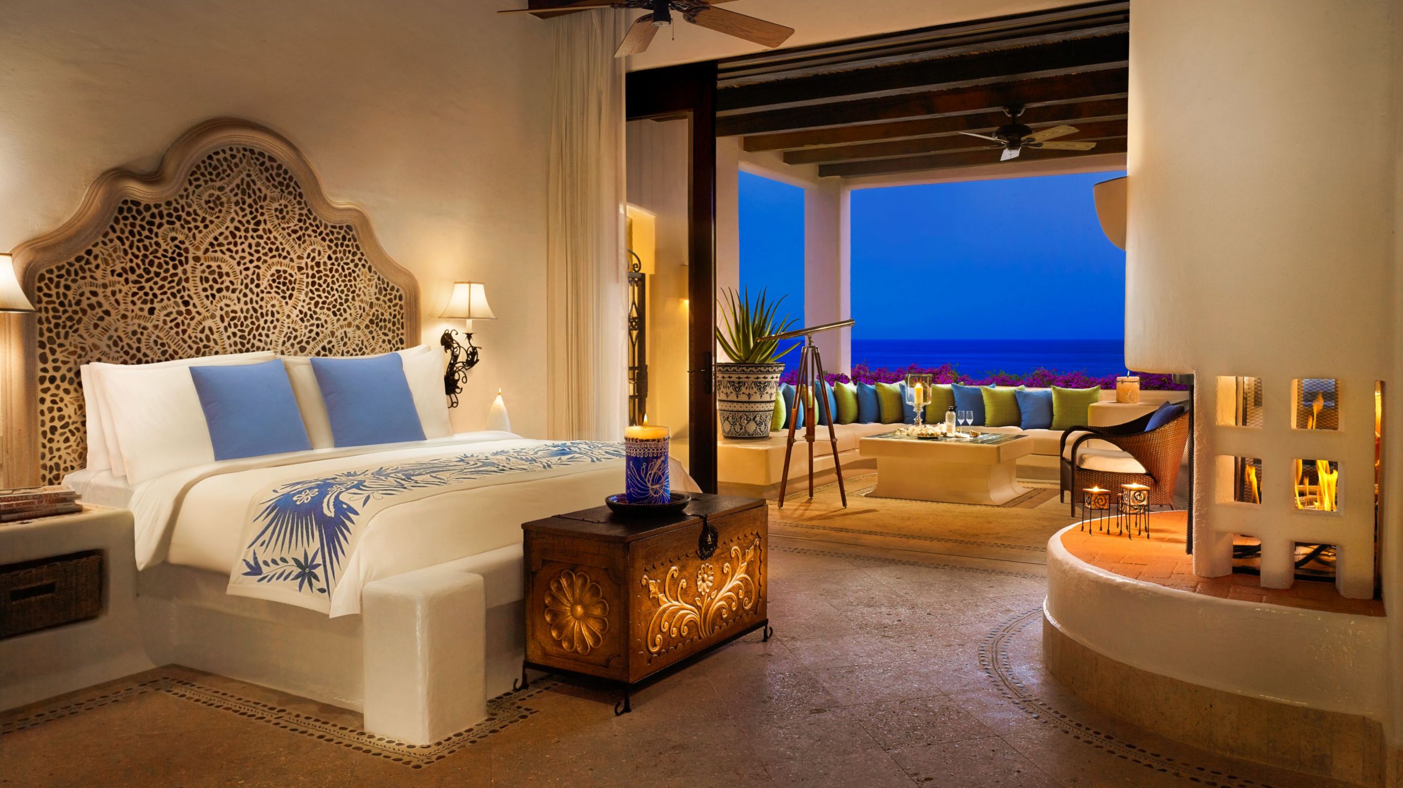 Luxury hotel suite in Los Cabos with a large bed with a decorated headboard and a private outdoor area.