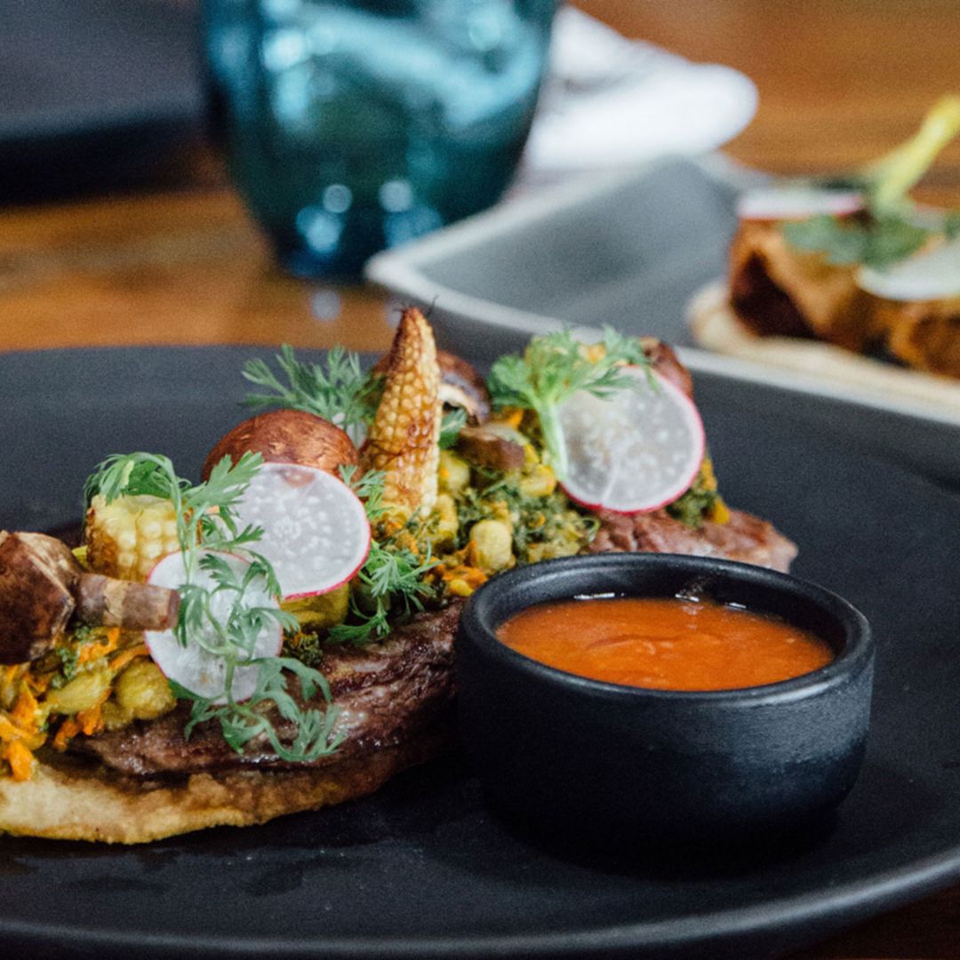 Vegetable quesdilla from Punta Bonita topped with veggies and served with a side of salsa