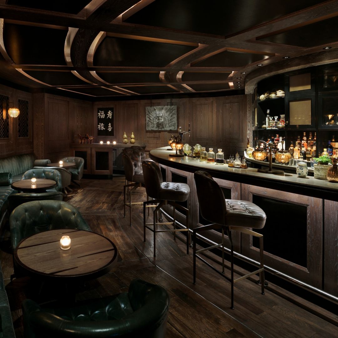 A dimly lit bar in Abu Dhabi with shelves showcasing an array of bottles.