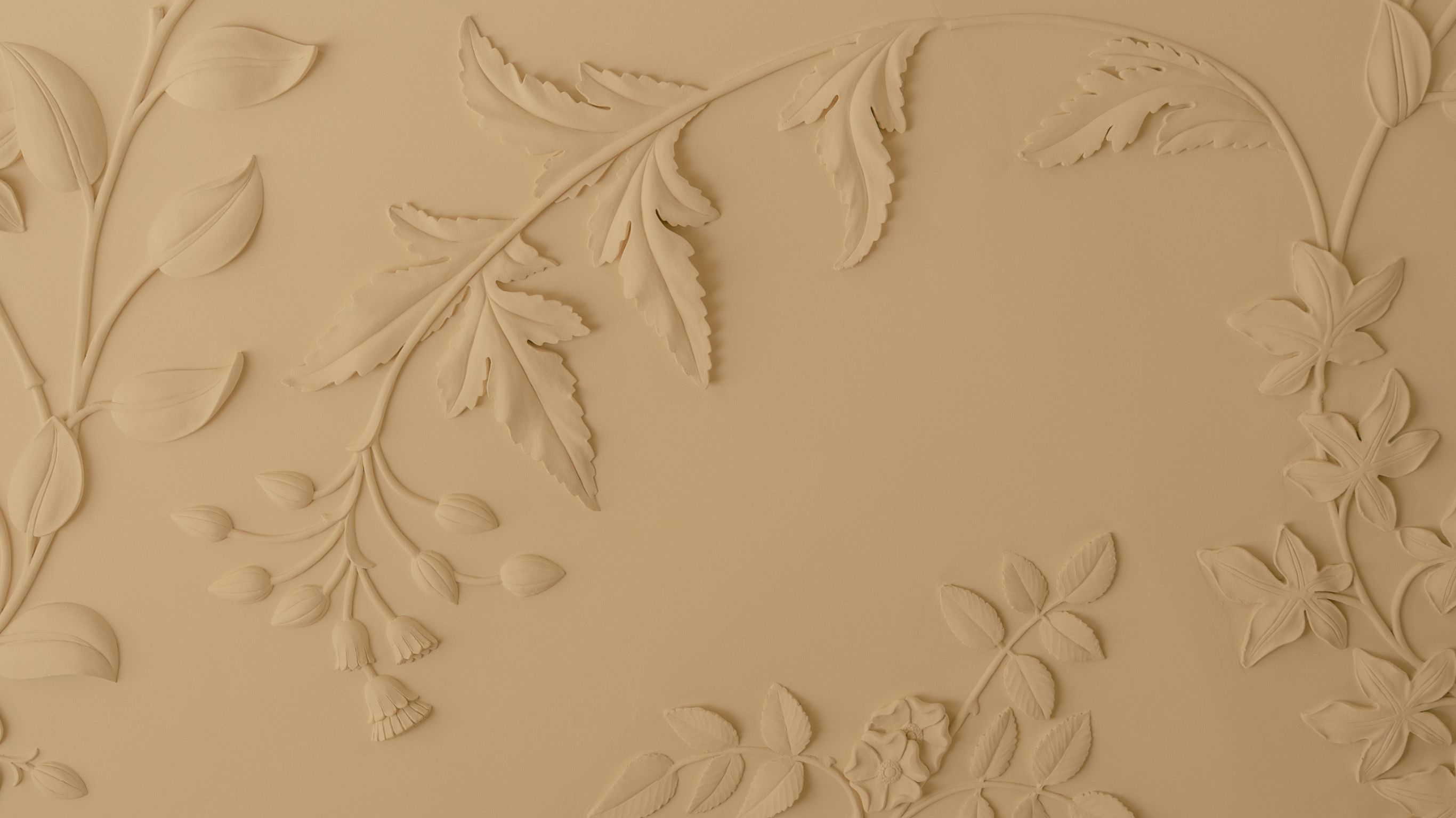 Decorative beige wall with embossed leaf  patterns.