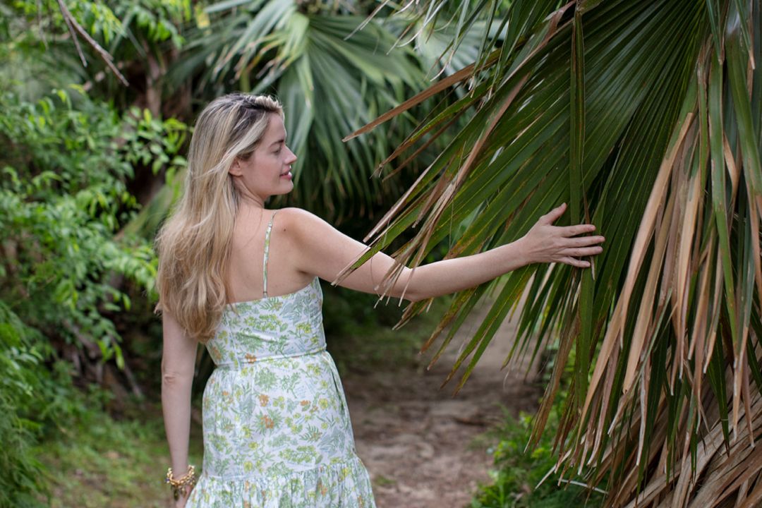 sarah bray walking through spittal pond trail with palm leaves