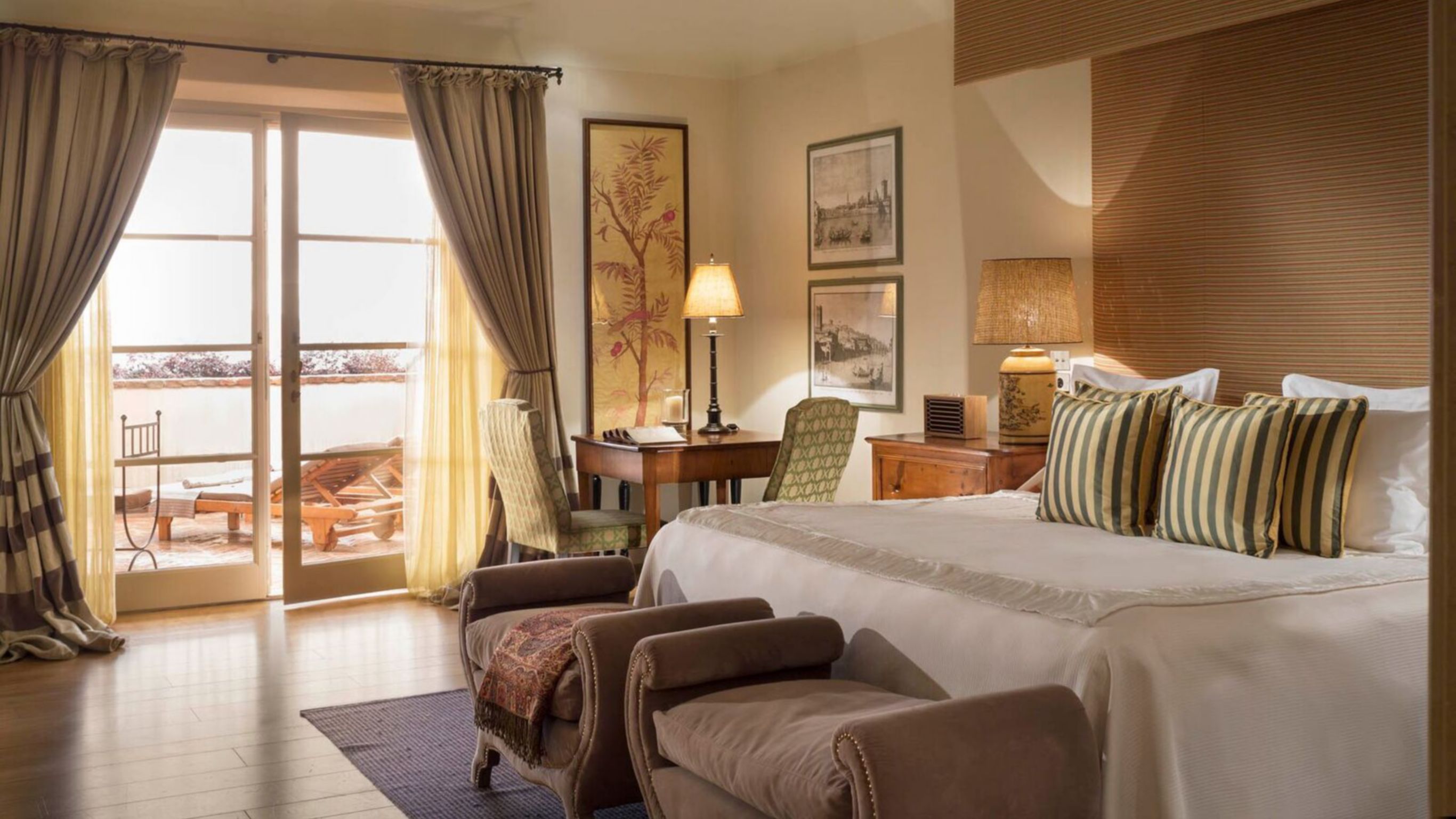 Hotel room with a bed, nightstand, lamp, and  framed pictures on the wall