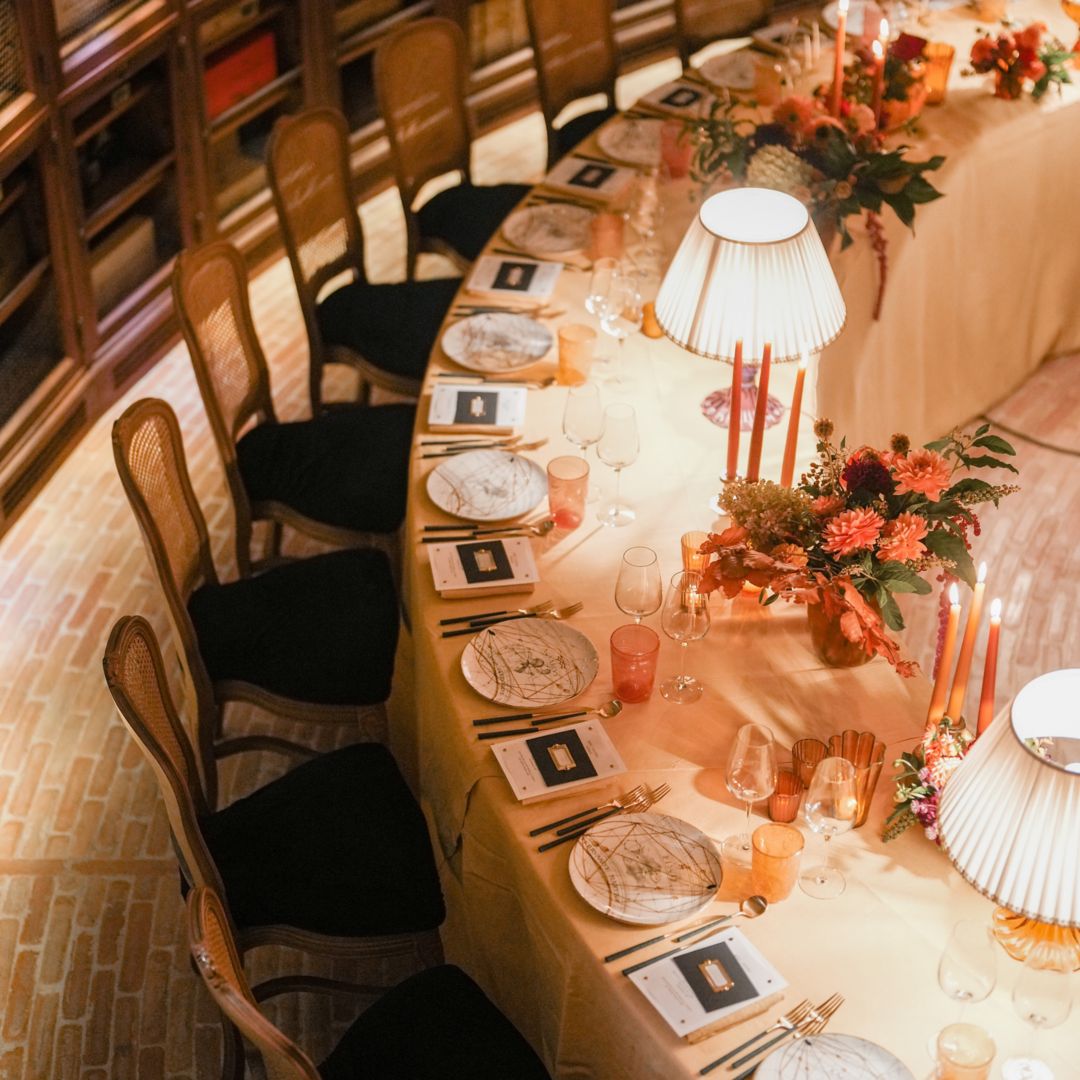 Dark grapes hanging on a vine with green  leaves in the background.