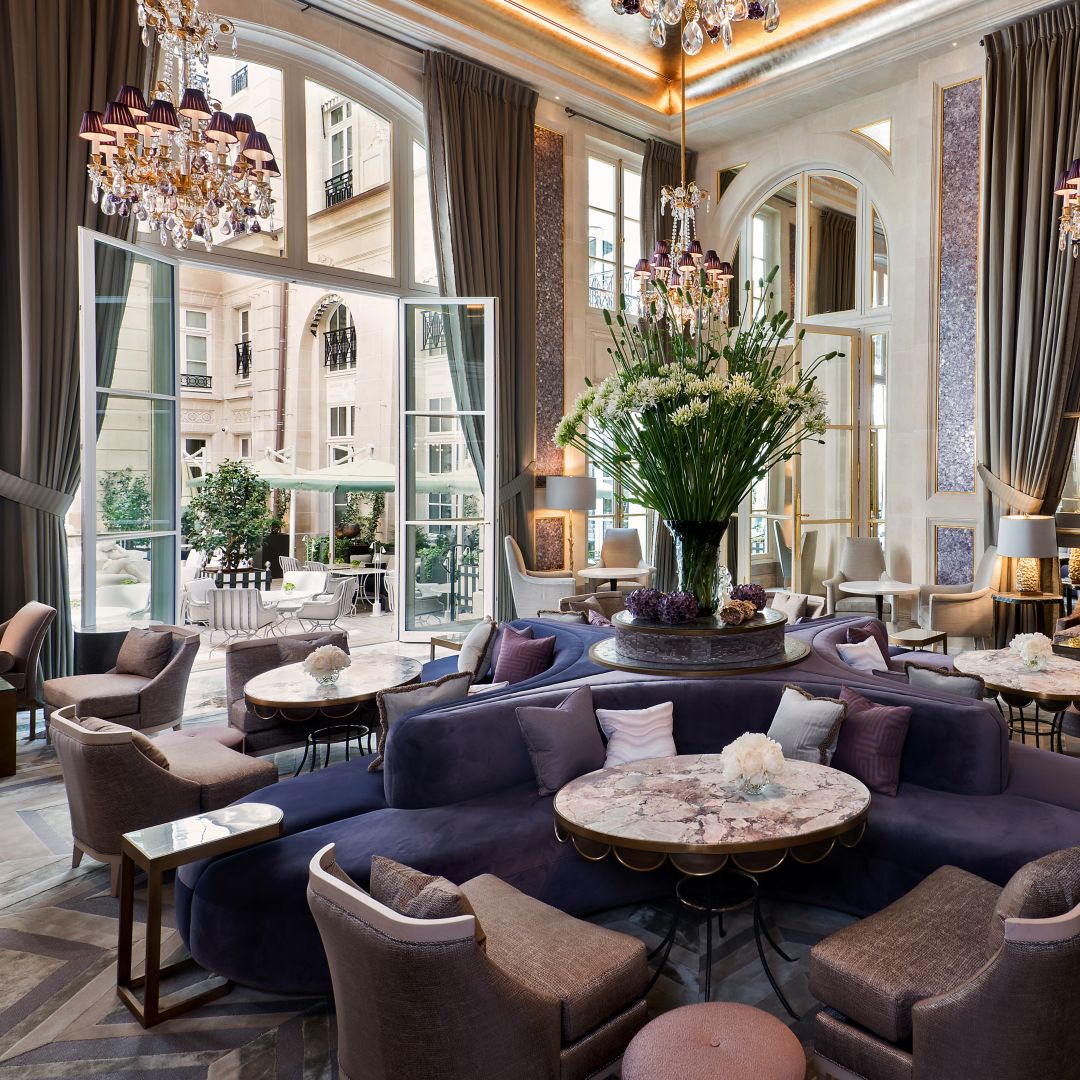 A luxurious lounge area with plush seating in  shades of purple and gray.