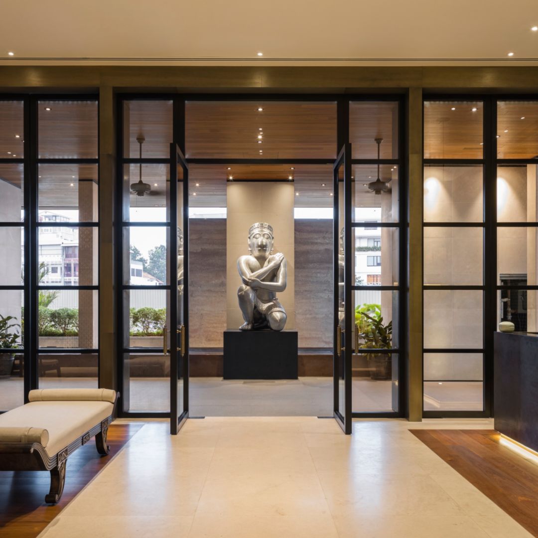 A hotel lobby with a statue in the center, surrounded by glass doors and warm lighting.