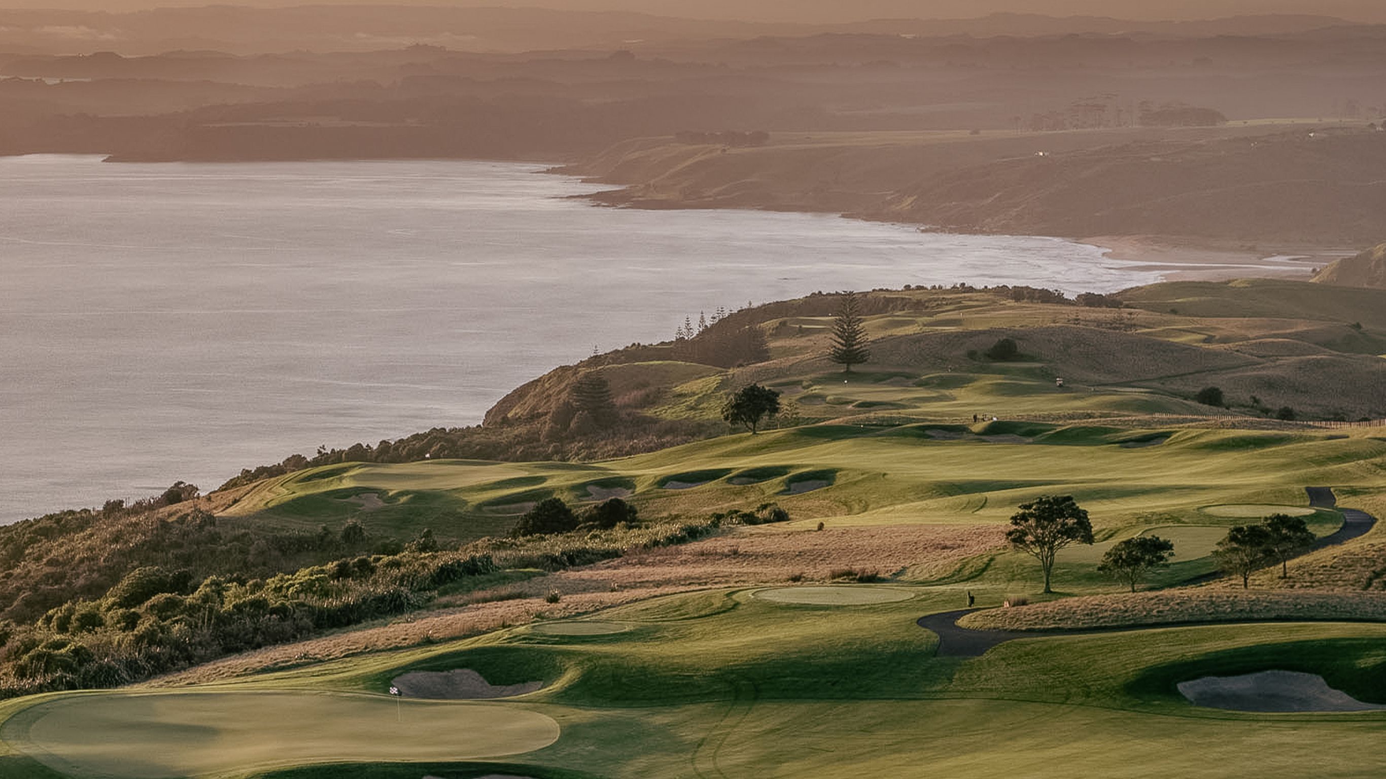 Aerial view across the golf course looking towards Takou Bay at dusk.