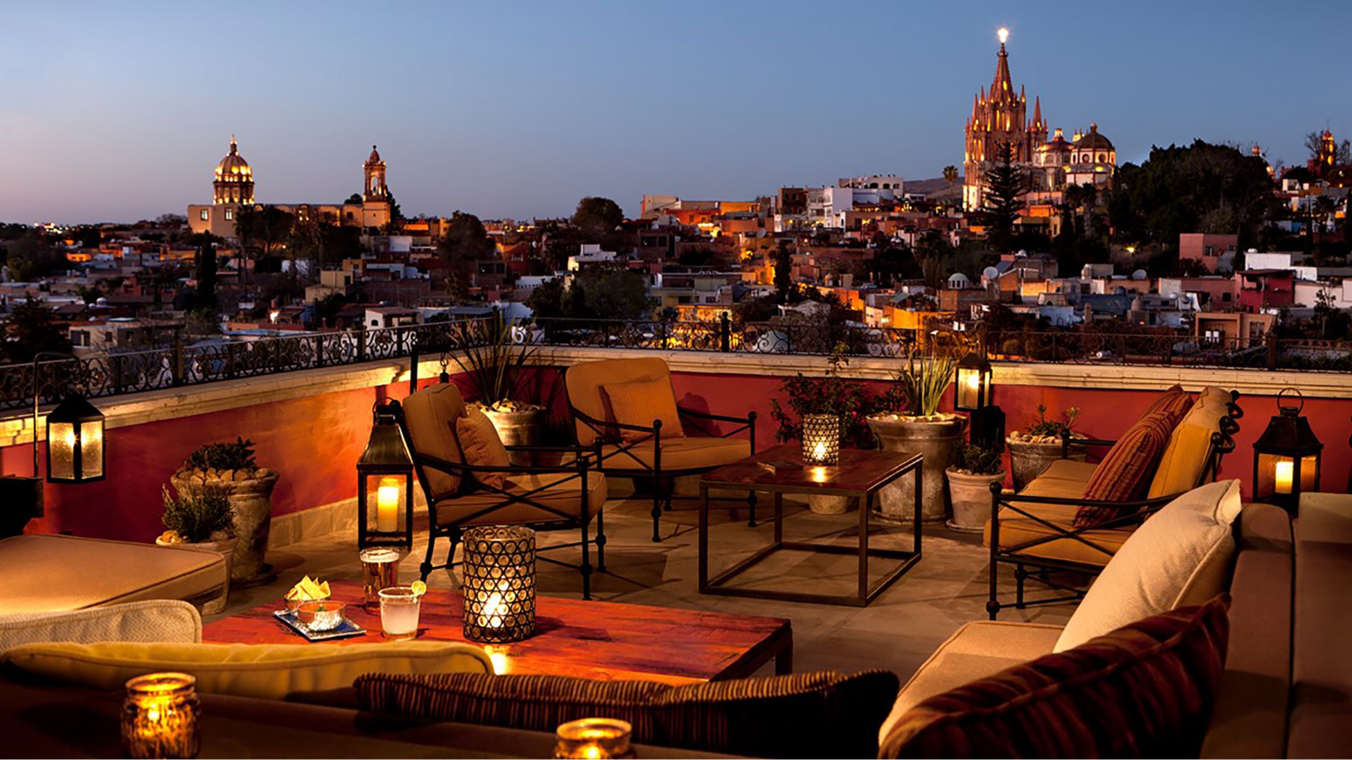 a rooftop bar with a city in the background