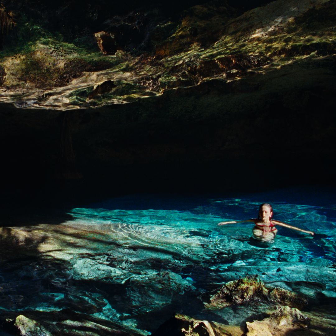 Tropical luxury resort pool with palm trees, sun loungers, and bright blue skies for a relaxing getaway.